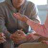 Two men sit in group talking