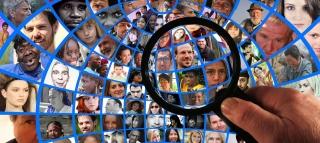 magnifying glass focusing in on grid of diverse faces 