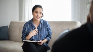 Woman sitting on couch talking 