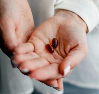 Close-up photo of the palm of a hand holding two red pills