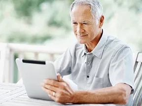 older white man looking at a tablet