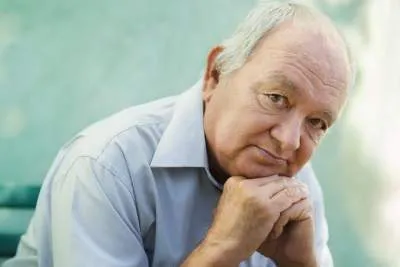 Portrait of an older balding white man who appears to be sad