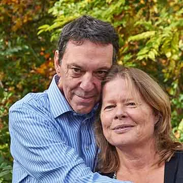 older white couple smiling softly and embracing outside