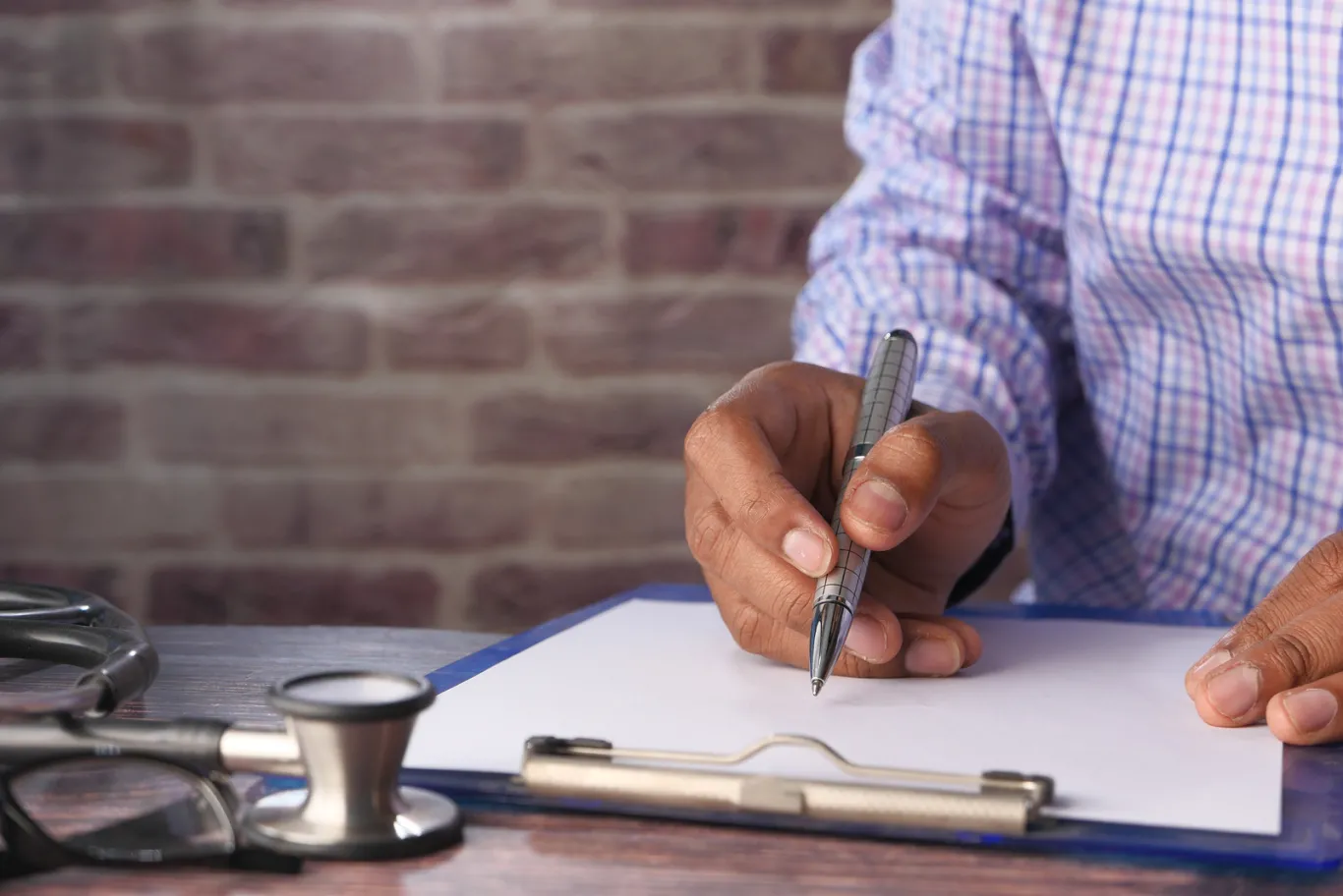 Doctor writing on clipboard