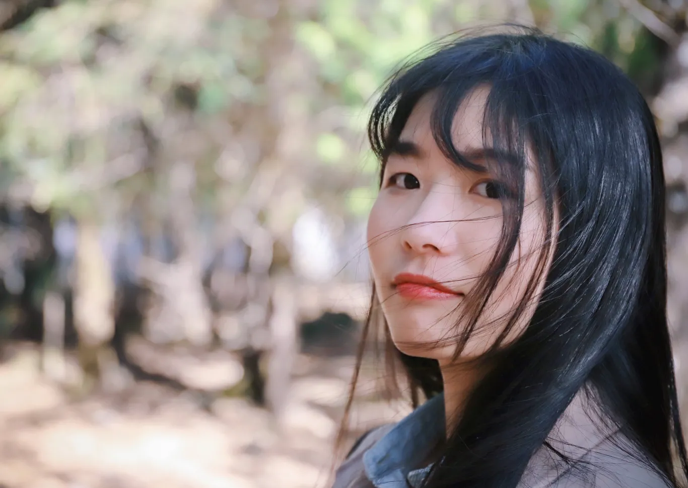 A young Asian-American woman smiles in the sunshine
