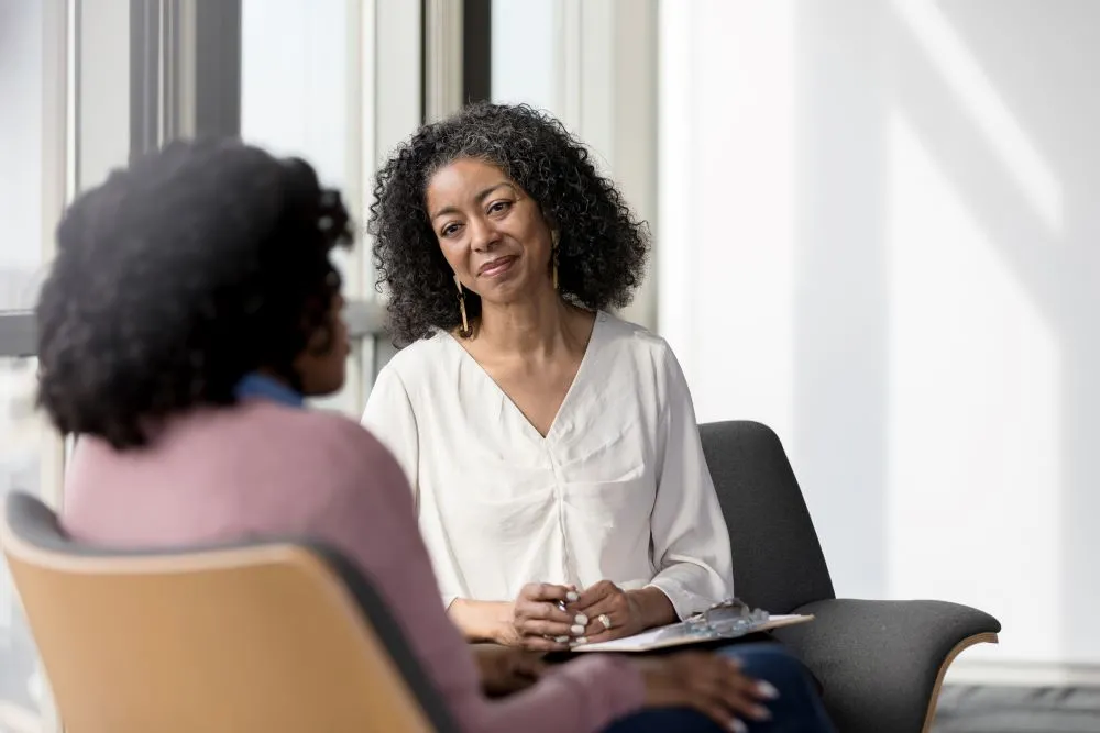 a woman counselor meeting with another woman