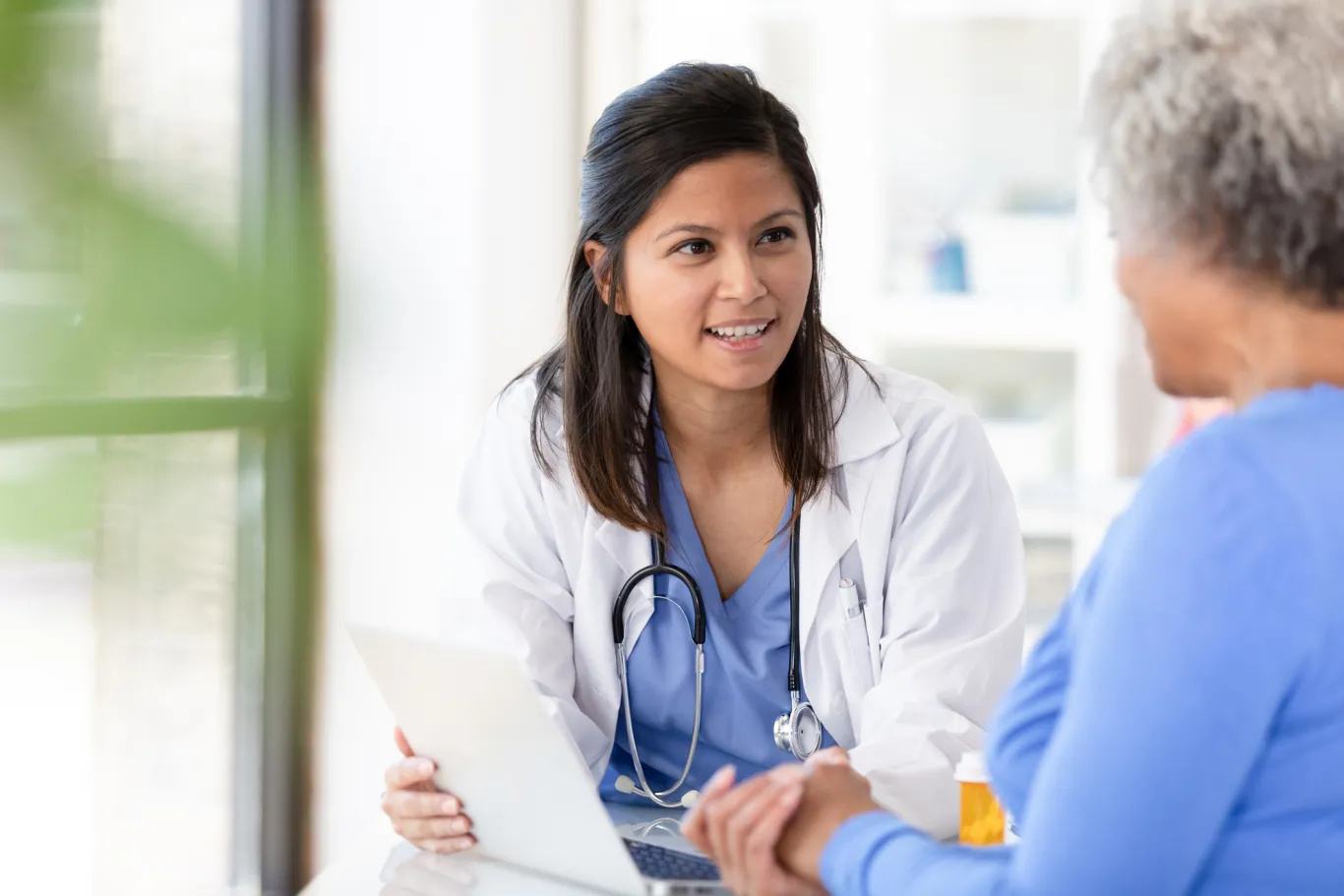 A seated doctor discussing a file with a patient