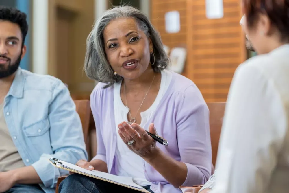 A woman sitting and talking to others in a group
