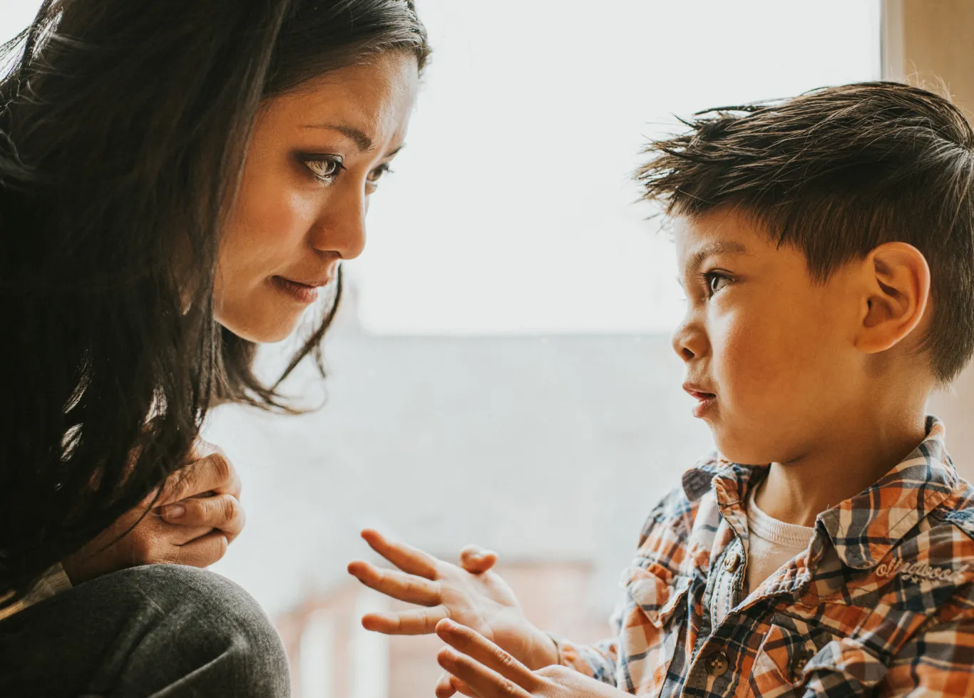 A woman listens as a young boy talks