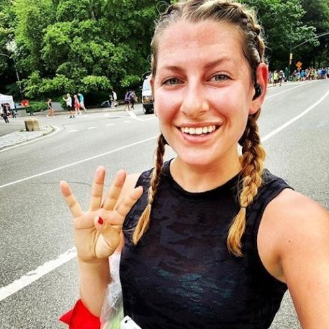 Dressed for a run, Michelle Cabot smiles and waves from the side of a street