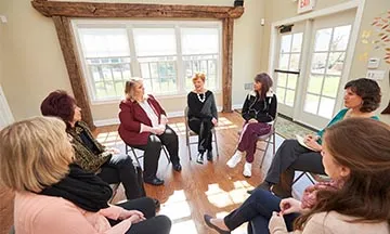 group of people sitting in a circle at a meeting
