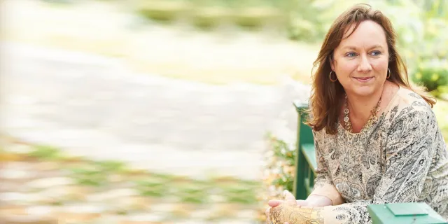 white woman with brown hair smiling outside