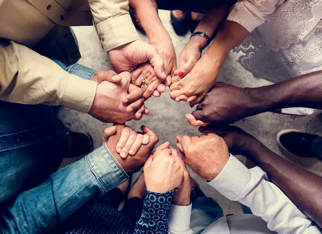 People of many races clasp hands in unity