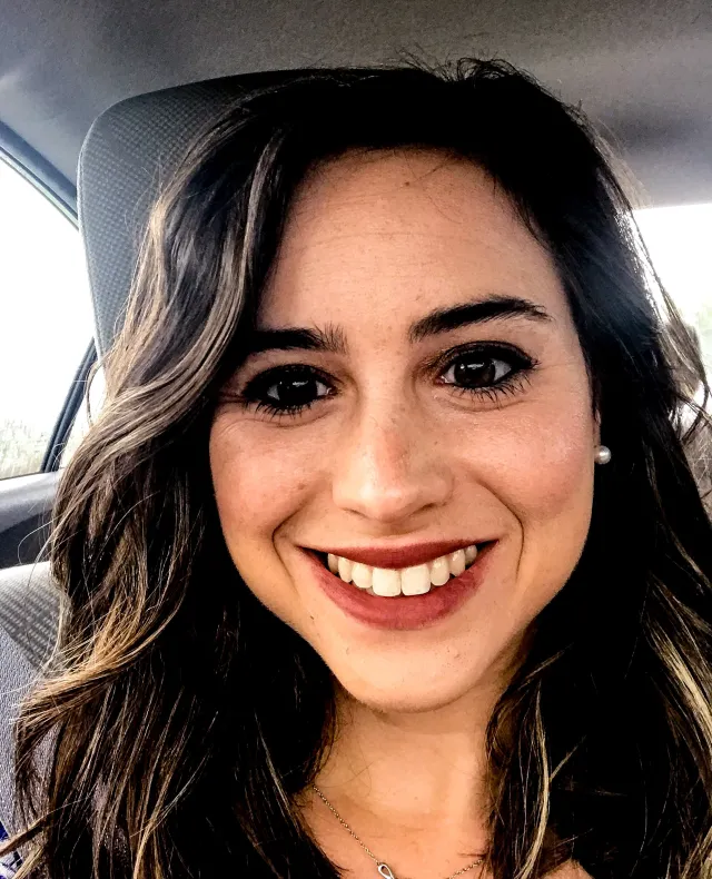 Alyssa smiles from inside her car