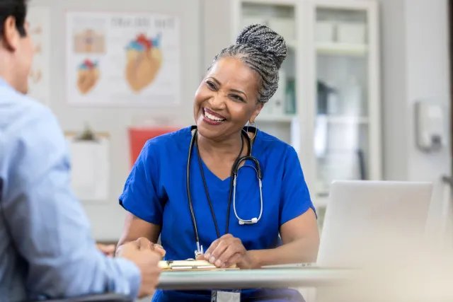 A female doctor smiling from behind a table