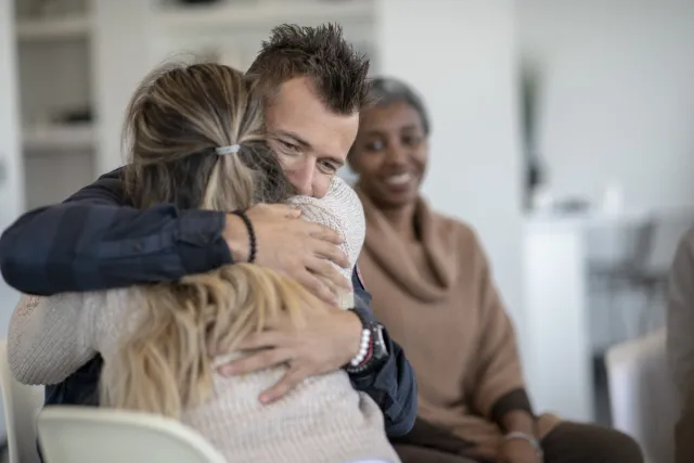 Showing support with a hug in group therapy