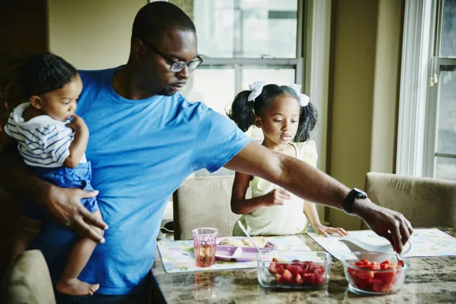 A father cooking in the kitchen with his children