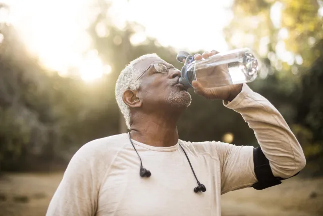 A man drinking water from a bottle outside