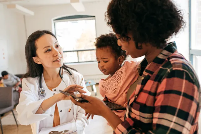 A nurse instructing a mother and her child