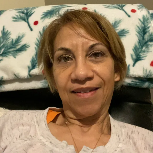 Elizabeth, a cancer survivor, smiles while sitting in a chair