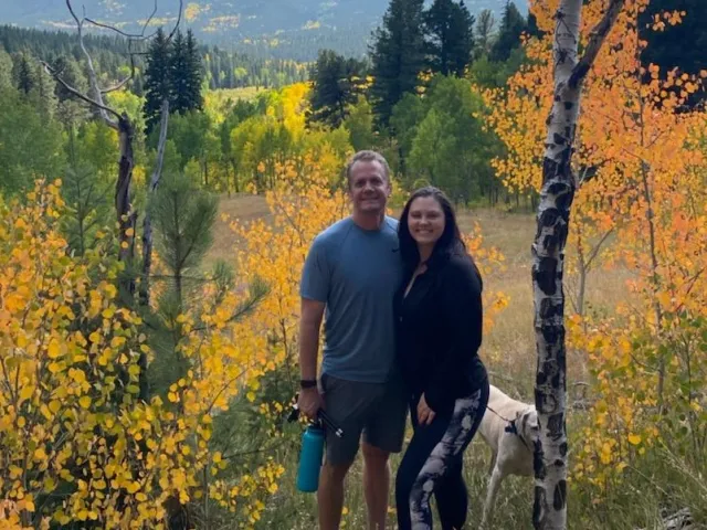 Amber and her husband enjoy the autumn colors on a mountain hike with their dog.