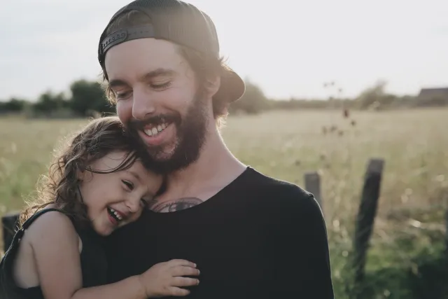 a man and a little girl laughing outside