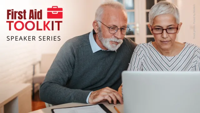 A husband and wife, both wearing glasses, look intently at a laptop screen together