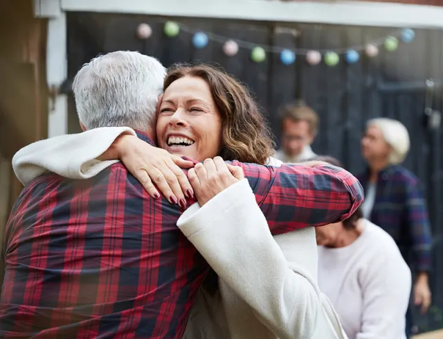 a man and a woman happily embracing at an outdoor gathering