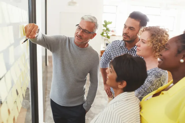 A man presenting ideas to a group of other adults