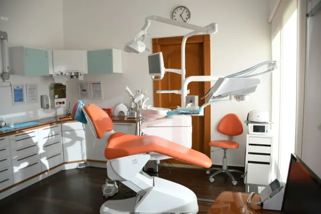A sunny dentist office with an organ dental chair and white cabinets