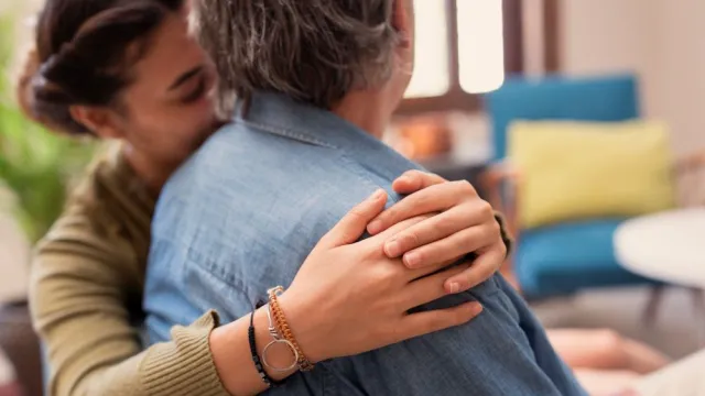 a woman lovingly hugs another person