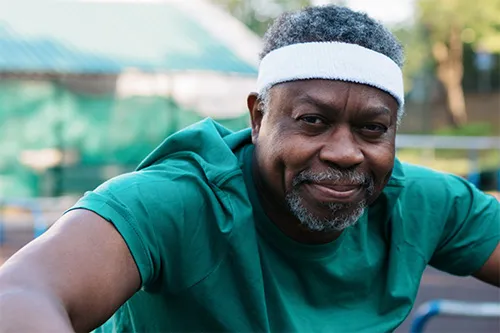 A smiling man wearing a headband