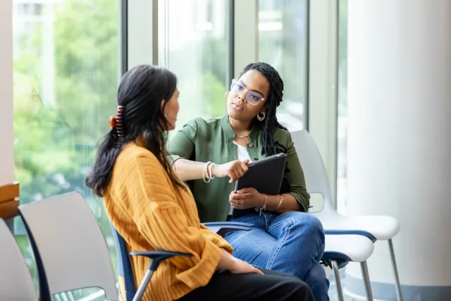 Two women sitting and talking in lobby