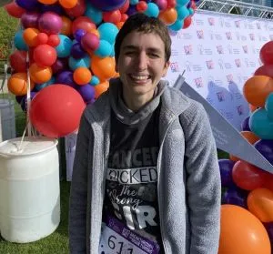 Elena smiles at a 5K event for a brain tumor association in Chicago and is surrounded by colorful balloons