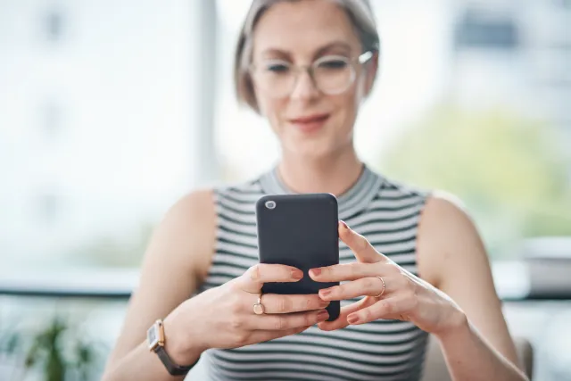 A lady looking at her phone and smiling