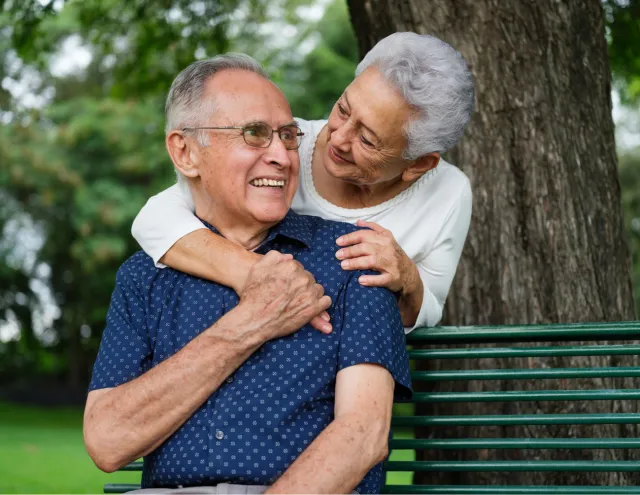Elderly couple sitting on bench 