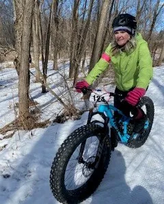 Lori rides a mountain bike in the snow