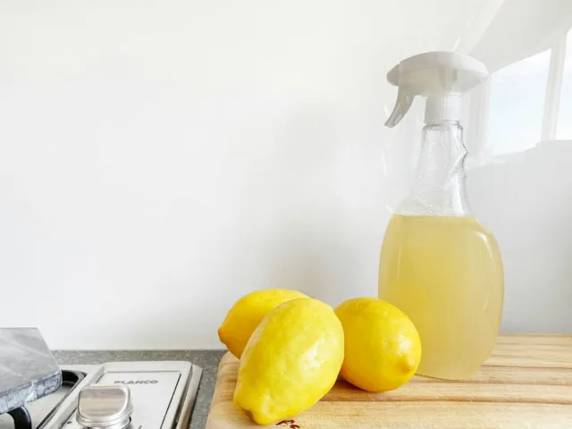 Lemons beside spray bottle of lemon water