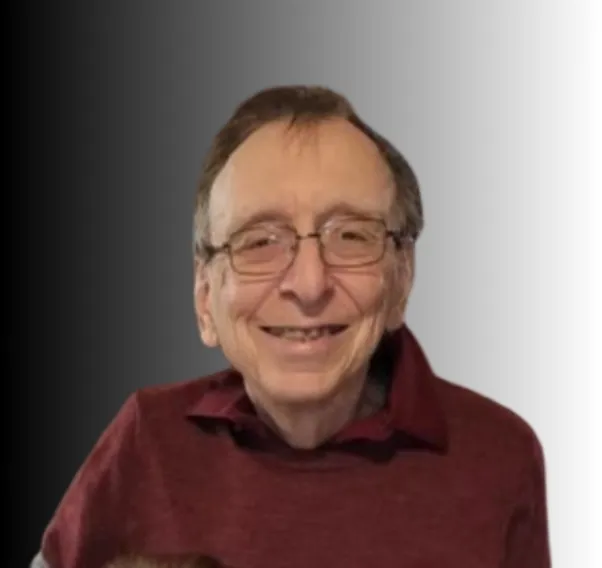 A headshot of Glenn wearing a burgundy dress shirt