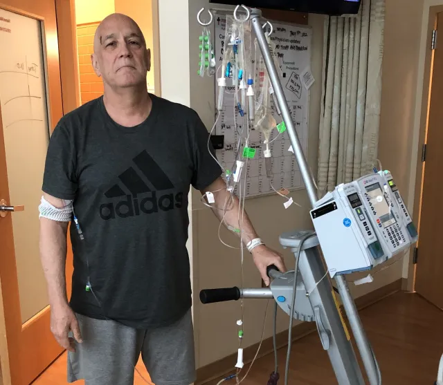 Jeffrey stands in a hospital room