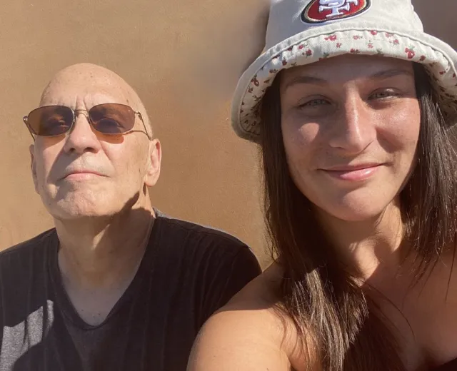 Jeffrey smiles with his daughter in a sunny location