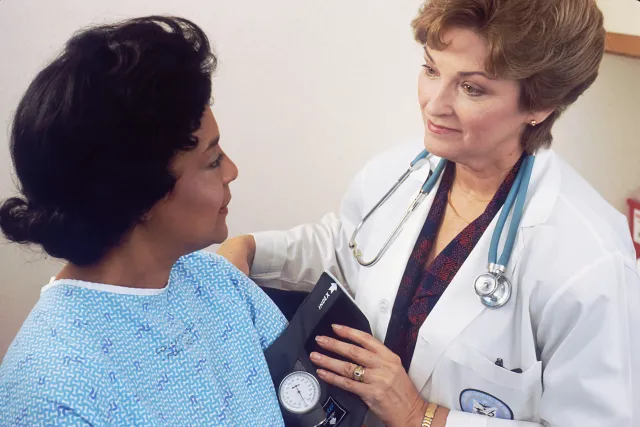Doctor checking patient blood pressure