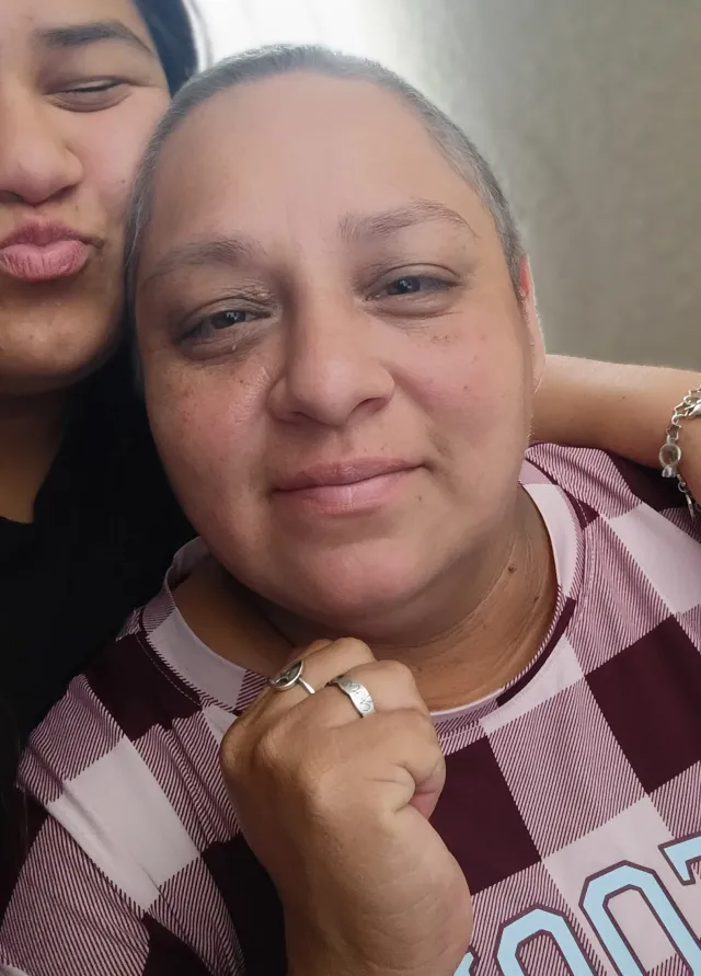 Sonya smiles with her daughter in the background