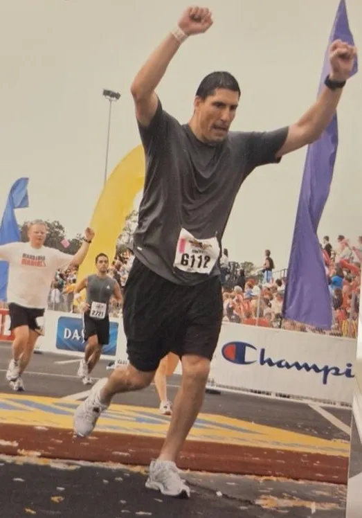 Kayla's dad crosses the finish line at a marathon in 2009