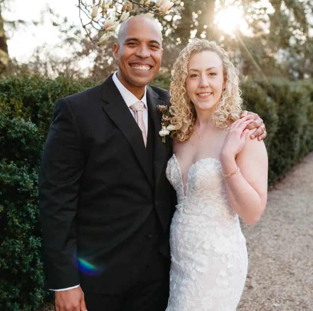 Brandon and Jackie on their wedding day beside a flowering tree