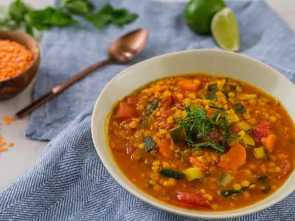 colorful lentil soup on a blue tablecloth 