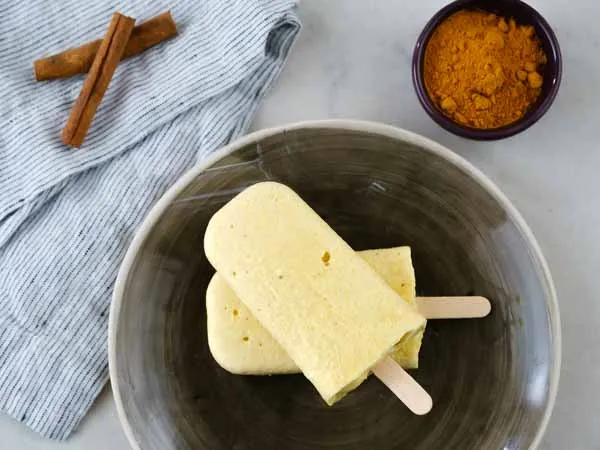 golden milk popsicles on a gray plate