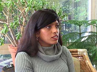 Woman in gray sweater speaking about melanoma