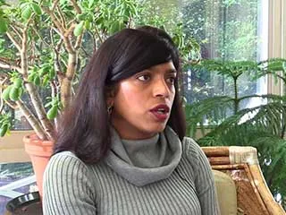 Woman in gray sweater speaking about melanoma