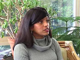 Woman in gray sweater speaking about melanoma